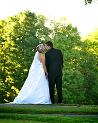 bride and groom sharing kiss on green